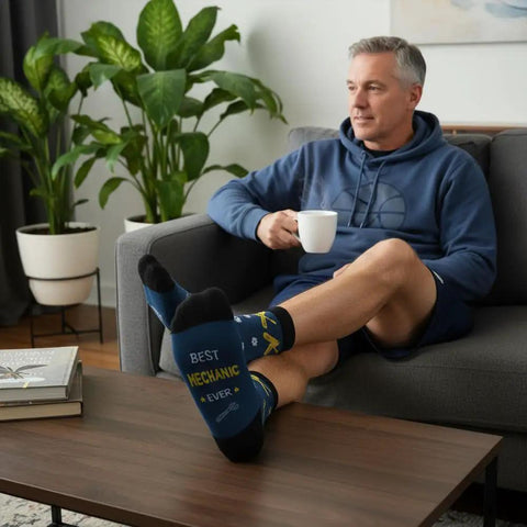 Man relaxing on sofa wearing Mechanic Socks Gift Set For Men And Women, Best Car Auto Repair Mechanic Appreciation Gift socks.