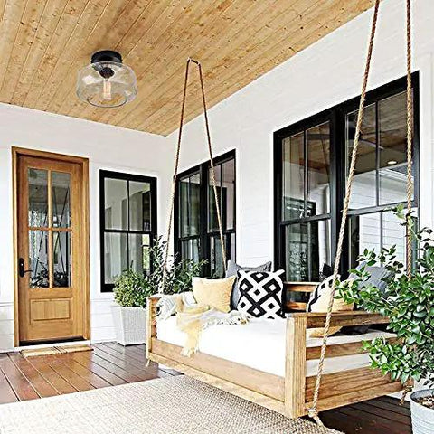 Heavy Duty Industrial Semi Flush Mount Ceiling Light With Tough Matte Black Frame And Authentic Seeded Glass Cover For A Big Time Modern Vintage Lighting Glow above a cozy porch swing.