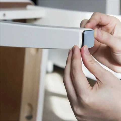 Person applying self adhesive furniture sliders for carpet hardwood and tile floors with 30mm chair leg glides on a chair leg.