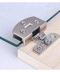 Close-up of Heavy Duty Stainless Steel Shower Screen Hinges For Glass Doors 5 To 9mm Clamp Clips on wooden base.