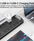 Six Foot Surge Protector Power Strip With Twelve Outlets And Four USB Ports, Heavy Duty Extension Cord, 2700 Joules, Overload Protection, Perfect For Home Office, Gaming Setup, And More. Black power strip with 12 outlets and 4 USB ports on desk
