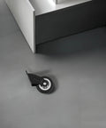 Heavy Duty Slider Wheels Rock Solid Construction For Quiet Barn Door Cabinet Sliding Track gliding wheel on gray floor with black housing.