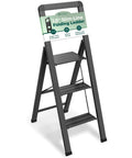Three Step Folding Step Ladder In Matte Black Aluminum With Locking Mechanism Ultra Slim Profile Anti Slip Steps Lightweight Yet Sturdy For Home Office Kitchen Photography Super Handy And Ready For DIY Projects, front view