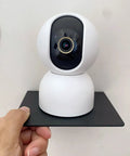 Straight Fire Black Metal Floating Wall Shelf For Echo Dot Alexa Smart Speakers Cameras Compact Rack holding a white camera on a black shelf.