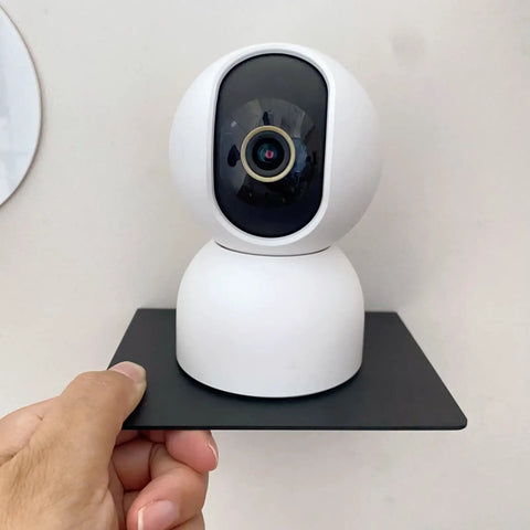 Straight Fire Black Metal Floating Wall Shelf For Echo Dot Alexa Smart Speakers Cameras Compact Rack holding a white camera on a black shelf.