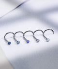 Five Pack 18g ASTM F136 Titanium Nose Studs With Vibrant Opal Tops For Nostril Piercings lined up on a white surface.