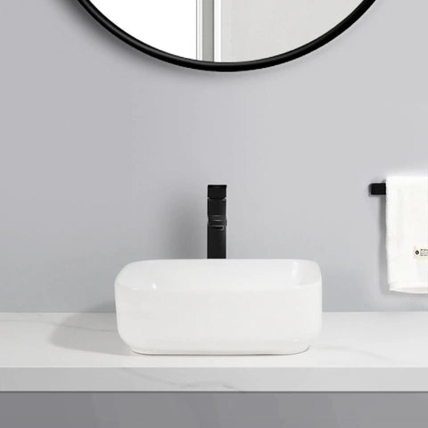 USZWBY Vessel Sinks Household Small Size Square Rounded White Countertop Ceramic Basin Bathroom Kitchen Sink Vegetable Bathroom Bowl Sink on a countertop with a black faucet.