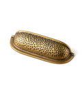 Six Pack 3 Inch Antique Brass Cabinet Cup Pulls With Hand Hammered Texture And Smooth Curved Edges, Ideal For Kitchen Cabinets, Drawers And Furniture, Delivering Timeless Vintage Charm With Modern Versatility And Easy Installation; close-up view of single cup pull
