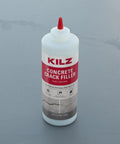 No Sweat Gray Concrete Crack Filler Dry Powder Blend Needs No Mixing Seals Cracks Up To Two Inches Wide in a bottle on a gray surface.