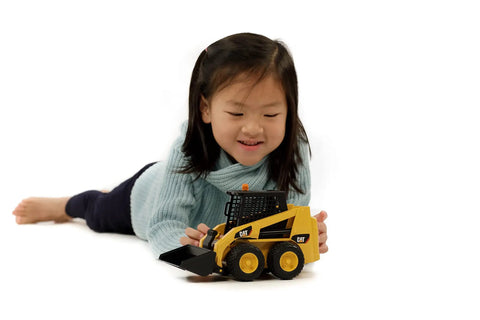 Child playing with Cat Skid Steer Loader Toy With Ultra Realistic Detail and Fully Functional Loading Arm, detachable bucket visible.