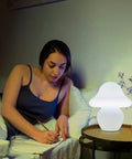 Milk White Glass Mushroom Lamp Small Translucent Nightstand Light for Bedroom and Living Room beside woman writing in bed.