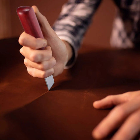 Person using skiving knife from Leather Craft Tool Set Six Piece With Four Edge Bevelers In 0.8mm, 1.0mm, 1.2mm, 1.5mm.