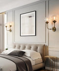 Antique Brass Double Sconce Wall Light With Clear 5.9 Inch Globe Shade in a bedroom setting, E26 Base, 110-120V, 60W Max