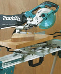 Miter saw mounted on compact folding miter saw stand with lightweight aluminum tubular frame, large wheels, side handle
