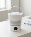 Sweet Compact Folding Mini Washing Machine Portable Travel Washer For Socks Underwear And Delicates Quick Rinse Auto Drain Straight Up Compact Design For Dorms on a table.
