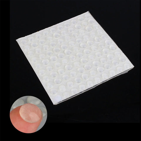 Close-up of 2 Inch Drawer Bumpers Set With Self Adhesive Silicone Feet For Quiet Cabinets And Drawers, 100 Count on a black background.