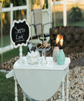 Outdoor table with two decorative glass table torches, durable fiberglass wick and metal snuffer, cozy ambience for dining or desk decor.