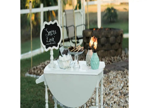 Outdoor table with two decorative glass table torches, durable fiberglass wick and metal snuffer, cozy ambience for dining or desk decor.
