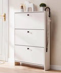 White cabinet with three drawers and black round knobs, featuring decor items on top and an umbrella hanging on the side.