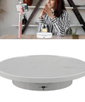 Hot 360 Degree Rotating Display Stand With Electric Motorized Turntable And USB Cable For Perfect Plastic Glass Showcase Of Jewelry Watches And Cakes In Crisp White in use with a perfume bottle.