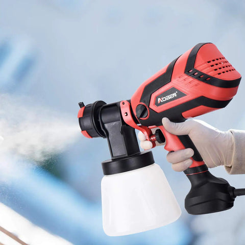 Hand holding a Powerful HVLP Paint Sprayer With 750W Motor And 4 Nozzles, 1000ml Cup for Home And Outdoor Projects in bright red.