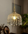 Top Shelf Vintage Crystal Pendant Light With Dope Diamond Cut Glass Shade And Legit Brass Accents Adjustable 0.5 To 70 Inch Cord hanging above illuminated in a cozy room.