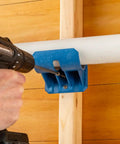 Premium Rockler Dust Right 4 Inch Hose Cradles shown in use with a drill to secure ABS clamp on PVC pipe.