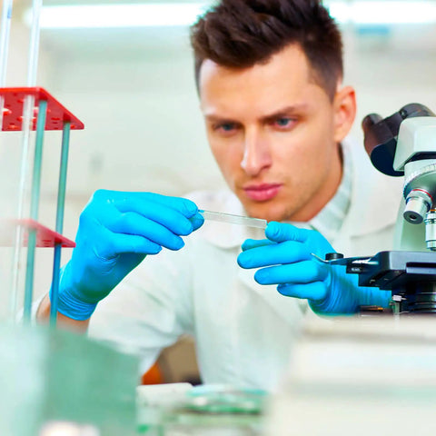 Lab technician using microscope, wearing Heavy Duty Nitrile Disposable Exam Gloves Medium Powder Free Latex Free 4 Mil 100 Count Non Sterile.