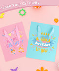 4 Pack Gift Bags With Handles 8 X 5 X 10 Inch Includes 8 Tissue Paper Color Combo Pink Purple Deep Blue Sky Blue Perfect For Birthday Parties Baby Showers Weddings Mothers Day Fathers Day Favors, featuring pink and sky blue bags with birthday designs on a pink background.