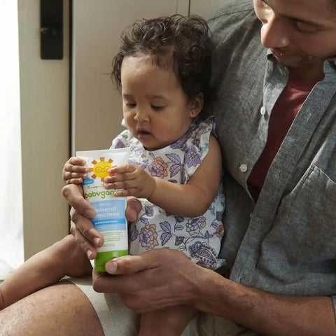 Parent holding Mineral SPF 50 Kids Sunscreen Lotion With Zinc Oxide And Titanium Dioxide Broad Spectrum UVA UVB 6 Fl Oz with child.