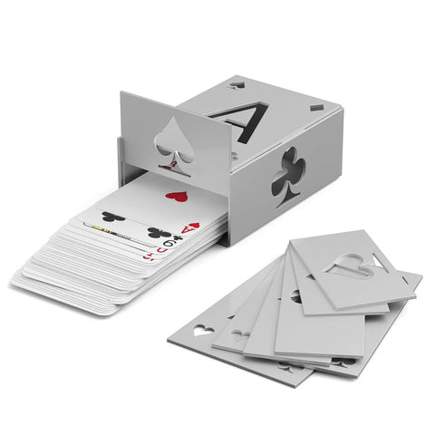 Deck of playing cards partially pulled from a silver card dispenser, with additional cards scattered beside it.