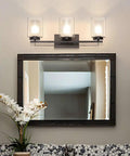 Dope 3 Light Bathroom Vanity Light in dark bronze with dual glass shades above a mirror, shown in a bathroom setting