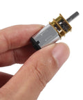Hand holding Six Volt DC Micro Gear Motor With All Metal Gears And N20 Gearbox 1000 RPM No Load 800 RPM Under Load 0.06 Kg Cm Torque
