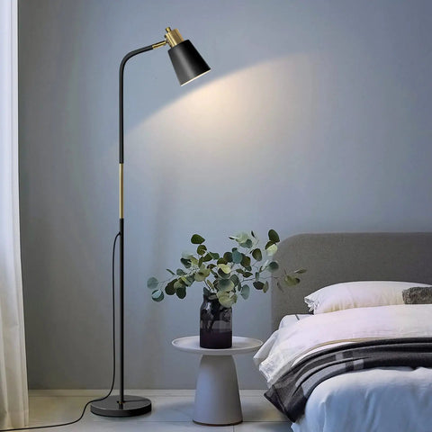 Three Color Temperature Floor Lamp With Adjustable Head And Energy Efficient Nine Watt LED Bulb Included For Living Room Bedroom Office Farmhouse Modern Standing Task Lighting For A Cozy Vibe next to a bed with a side table and plant.