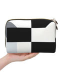Hella Cool Black And White Piano Plate Grid Print Portable Makeup Bag For Women Offering Tough Waterproof PVC Finish Travel Toiletry Organizer And Brush Holder held in hand.
