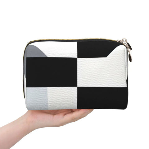 Hella Cool Black And White Piano Plate Grid Print Portable Makeup Bag For Women Offering Tough Waterproof PVC Finish Travel Toiletry Organizer And Brush Holder held in hand.