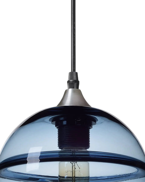 Close-up of hand blown glass pendant light in modern blue with brushed nickel globe, part of a 7.4 inch diameter three pack set.