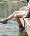 Person wearing Waterproof Rain Boot Covers For Men And Women, Reusable Foldable Overshoes by the water, showing non-slip design.