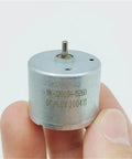 Hand holding Dope Tiny 24mm Mini Electric Motor Spindle for DIY Projects, visible text on motor casing.