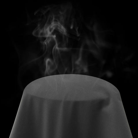 Steam rising from the surface of a dark material object, representing its waterproof and windproof properties.