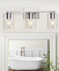 Three Light Vanity Wall Light in Brushed Nickel for Bathroom Over Mirror with Glass Shade above white framed mirror
