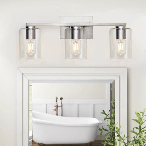 Three Light Vanity Wall Light in Brushed Nickel for Bathroom Over Mirror with Glass Shade above white framed mirror