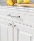 Close-up of kitchen cabinet with stainless steel handles and a marble countertop, featuring lemons and limes on a wooden board.