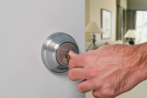Hand using key on SmartKey Security Exterior Deadbolt With Keyed Entry In Satin Nickel Model 980 Quick Rekey In Seconds In 3 Easy Steps
