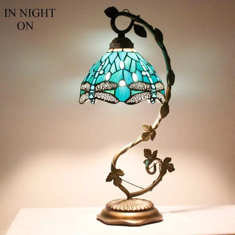 Green Stained Glass Dragonfly Tiffany Style Table Lamp With Metal Leaf Accent, cozy desk reading light in night mode.