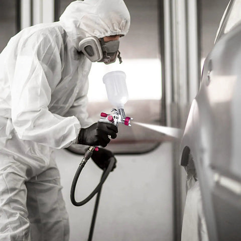 Person using Pro Grade Mini HVLP Sprayer Kit With 1.0mm Nozzle, wearing protective gear, painting a car for smooth auto body finish