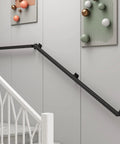 12 Ft Matte Black Wrought Iron Wall Mount Railing Beast Mode Heavy Duty Non Slip Handrail for Stairs Porch Deck Supports 440 Lbs Corrosion Resistant Indoor Outdoor Banister Bad Ass Grip mounted on a wall.