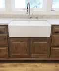 Legit Reactive Water Based Wood Stain With A Slick Reclaimed Vibe Weathered Tan Tones Hit Different On Any Surface Voc Free Solid Formula For Interior Or Exterior Jobs In 55 Gallon Drum on a wooden cabinet with white farmhouse sink.