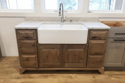 Legit Reactive Water Based Wood Stain With A Slick Reclaimed Vibe Weathered Tan Tones Hit Different On Any Surface Voc Free Solid Formula For Interior Or Exterior Jobs In 55 Gallon Drum on a wooden cabinet with white farmhouse sink.
