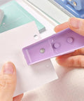 Hands using Rugged Heavy Duty Single Hole Punch for Papers and Crafts 40 Sheets Capacity One Quarter Inch Purple Hole Puncher